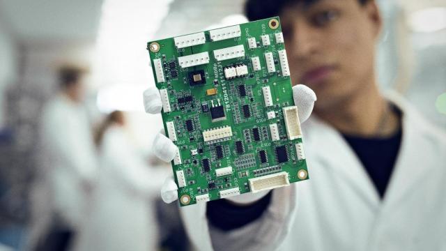 Un trabajador de TAIA enseña uno de los circuitos integrados de la compañía alcoyana.