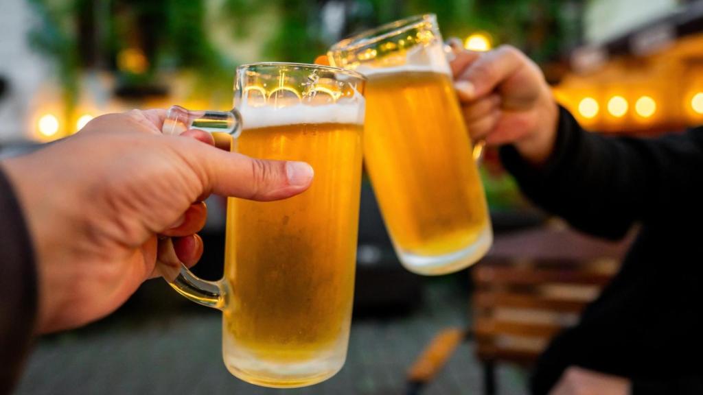 Dos personas brindan con cerveza.