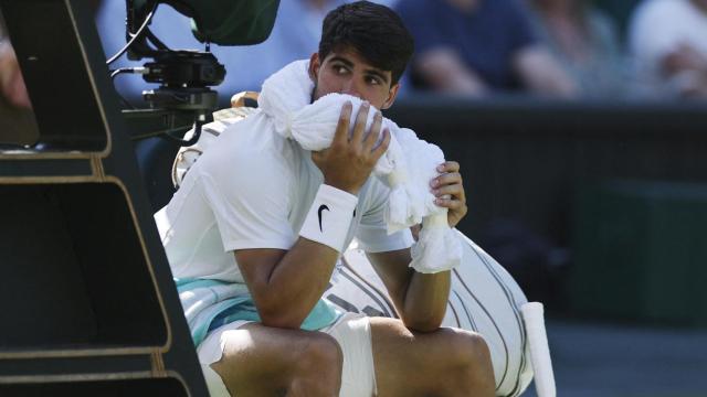 Carlos Alcaraz, refrescandose en su silla durante el partido ante Fogini en Wimbledon