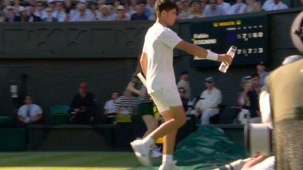 Carlos Alcaraz lleva una botella de agua fría a un aficionado afectado por el calor en Wimbledon