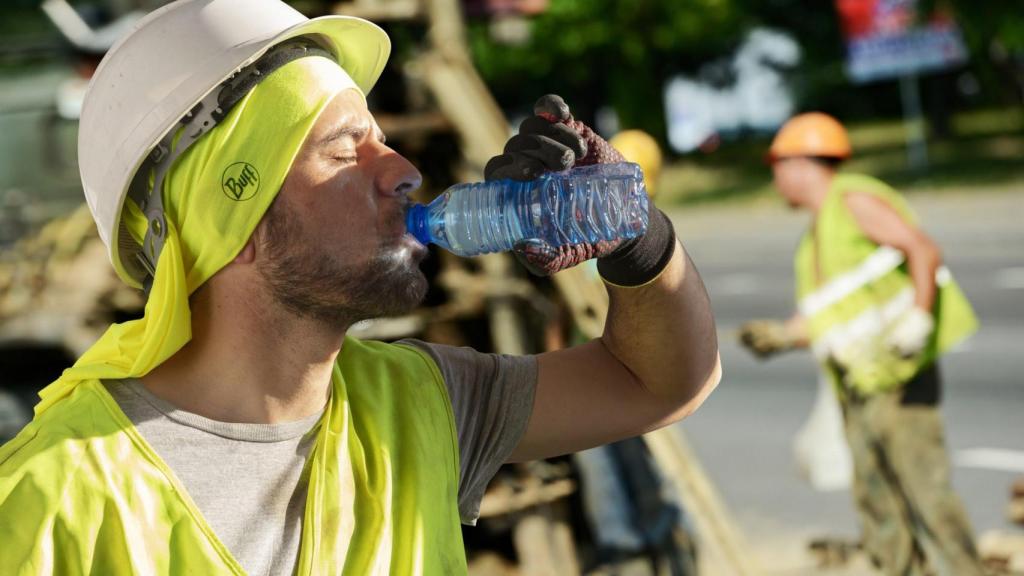 Un trabajador se refresca en su jornada laboral.