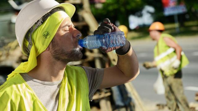 Un trabajador se refresca en su jornada laboral.