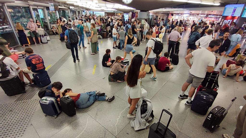 Cientos de personas esperan la salida de su tren en la estación de Atocha en Madrid este martes tras el anuncio de Adif de que los trenes con origen Madrid Puerta de Atocha-Almudena Grandes dirección sur no circularán, al menos, hasta las 08.45 horas.