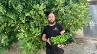 Raúl Gómez posando con los pimientos de su cooperativa