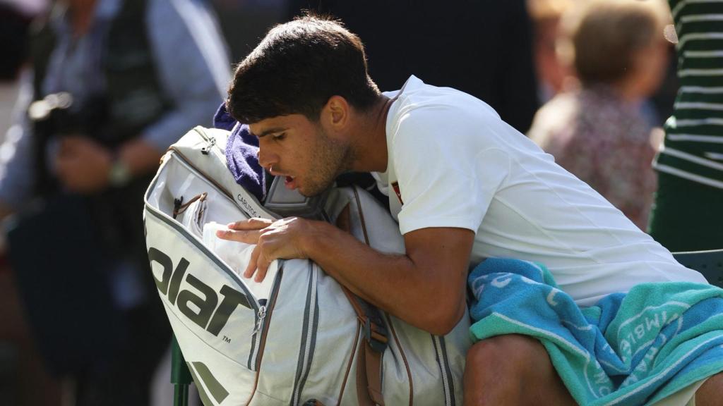 Carlos Alcaraz busca entre su bolsa durante uno de los parones.