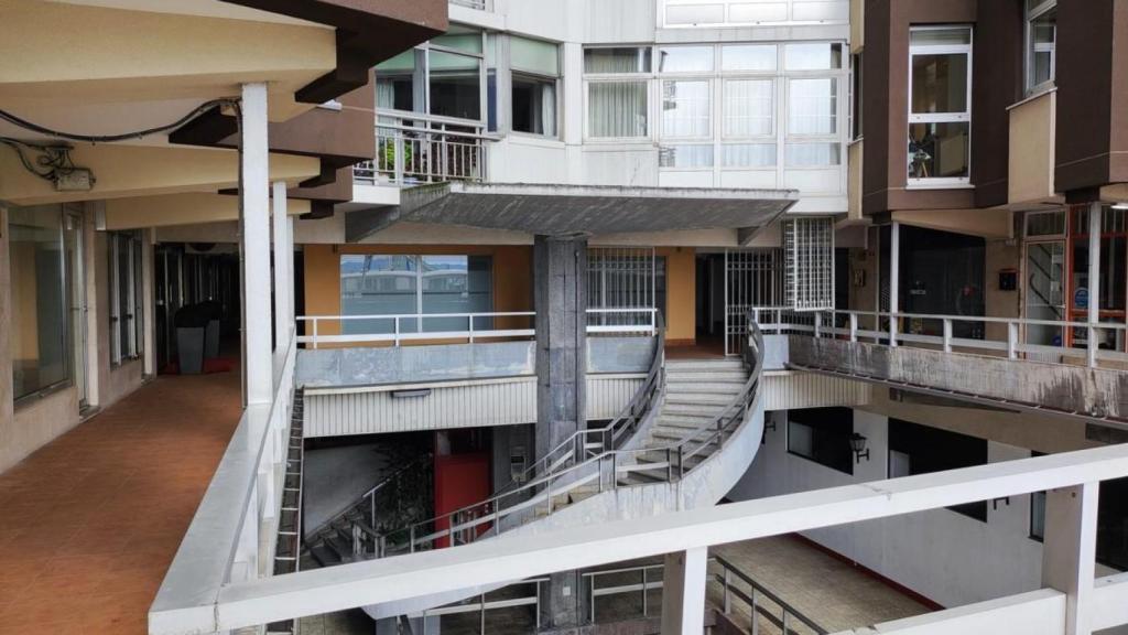 Entrada a las viviendas de la torre residencial por Linares Rivas, con los bajos comerciales en los laterales.