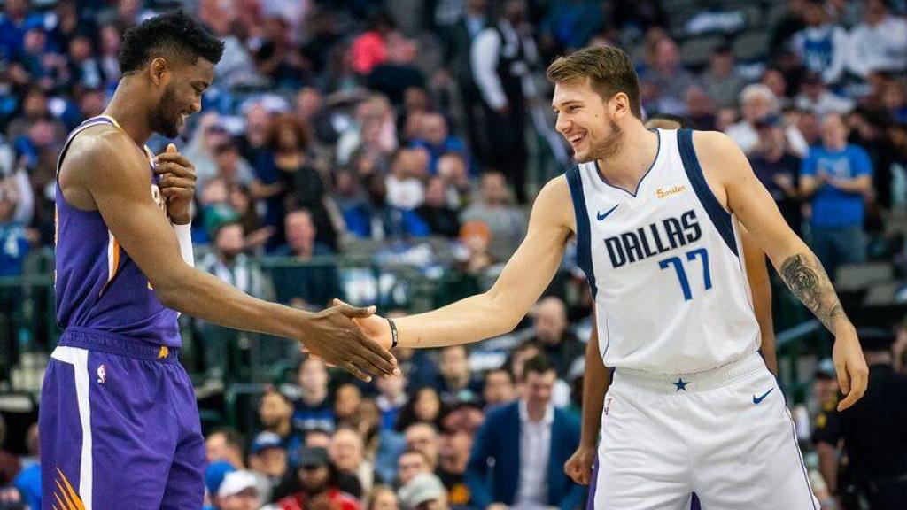 Deandre Ayton y Luka Doncic se saludan durante un partido.