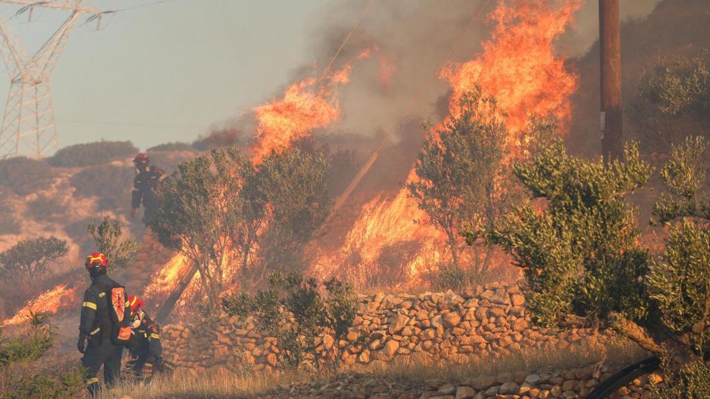 Los bomberos permanecen junto a las llamas mientras un incendio forestal arde cerca de Ierapetra, en la isla de Creta, Grecia, el 3 de julio de 2025.