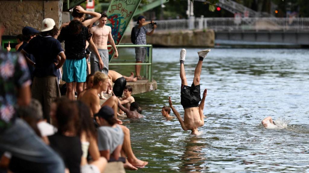 Un grupo de jóvenes salta al canal Saint-Martin en un día soleado y caluroso de verano en París, mientras una ola de calor temprana azota Francia, el 2 de julio de 2025.