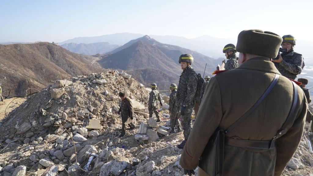 Imagen de archivo de soldados surcoreanos y norcoreanos inspeccionando el puesto de guardia norcoreano desmantelado dentro de la Zona Desmilitarizada.