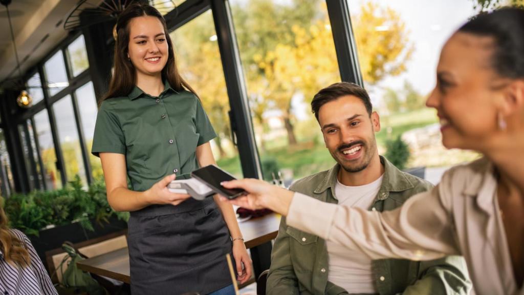 Un grupo de personas pagando la cuenta en un restaurante