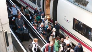 Pasajeros junto a un AVE en la estación de Santa Justa de Sevilla.
