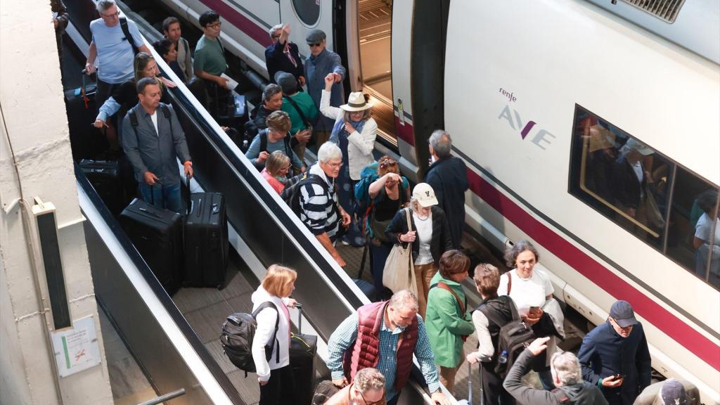 Pasajeros junto a un AVE en la estación de Santa Justa de Sevilla.