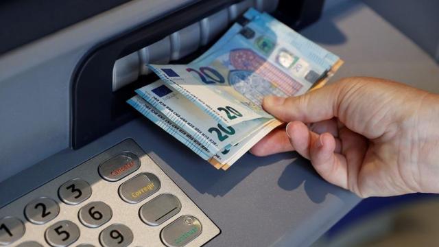 Una persona saca dinero de un cajero.