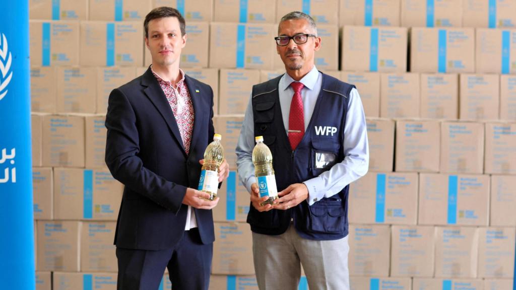 Viktor Bort, ex Encargado de Negocios de la Embajada de Ucrania, y Patrick Teixeira, Director Adjunto de País del PMA en Mauritania , posan con suministros donados por Ucrania durante una ceremonia que marca la llegada de los suministros donados por Ucrania , como parte de la iniciativa Granos de Ucrania