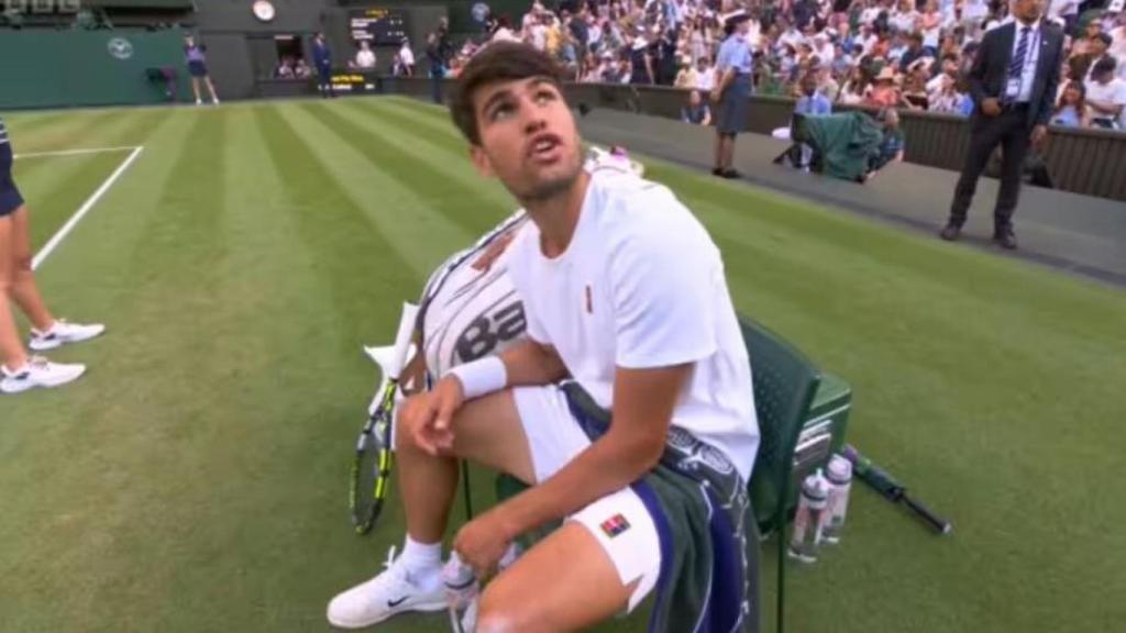 Carlos Alcaraz conversa con el juez de silla durante el partido en Wimbledon
