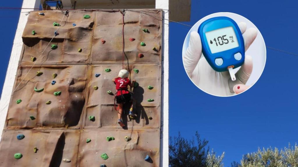 Un niño subiendo un rocódromo en el campamento de verano de diabetes de Málaga.