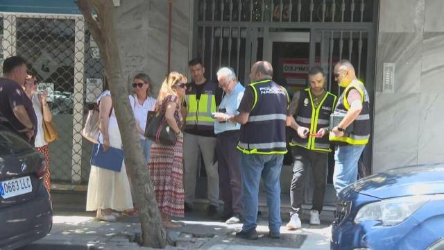 Agentes de Homicidios, en la entrada del edificio de Getafe donde se halló el cadáver.