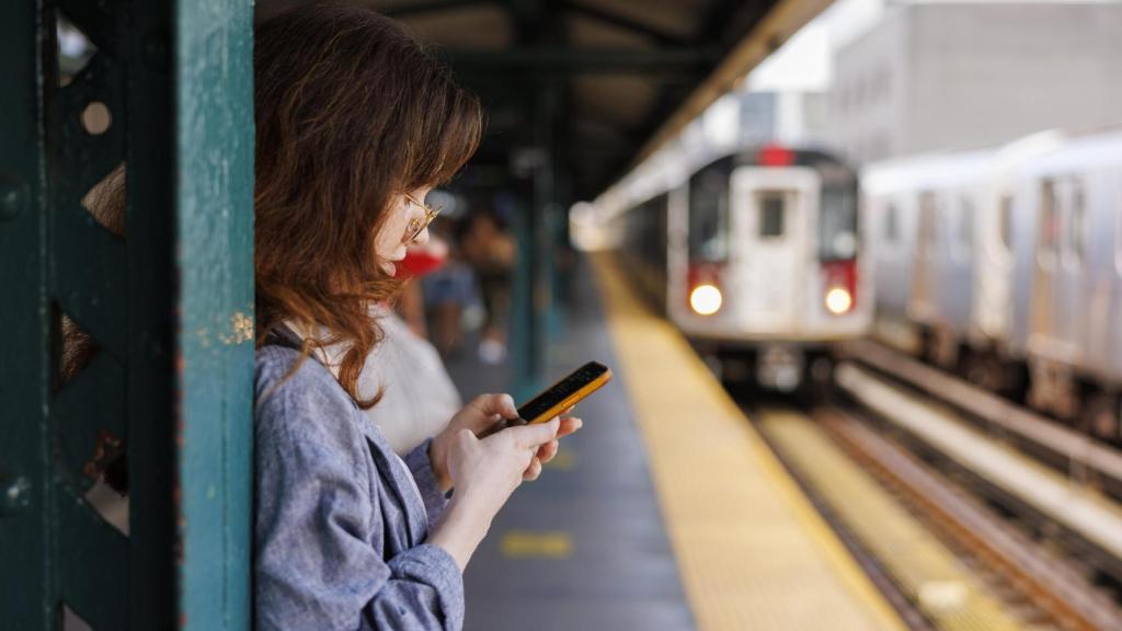Chica joven esperando a que llegue el tren.