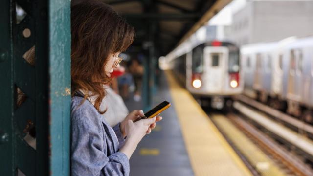 Chica joven esperando a que llegue el tren.