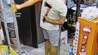 Uno de los implicados entrando con un hacha al bar antes de empezar la reyerta