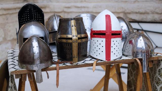 Diferentes tipos de cascos de armadura exhibidos en una feria medieval