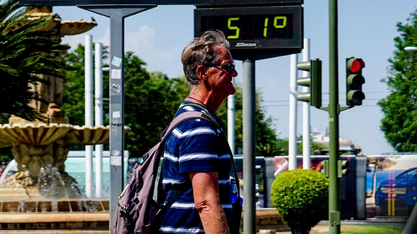 Transeúntes en Sevilla, donde un termómetro supera los 50 ºC.