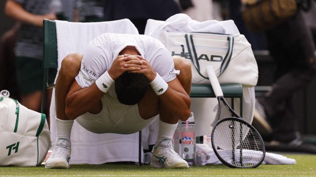 Novak Djokovic realiza estiramientos durante un descanso en el partido ante Alex de Minaur en Wimbledon