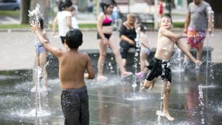 Unos niños refrescándose en una fuente en Salamanca durante una ola de calor