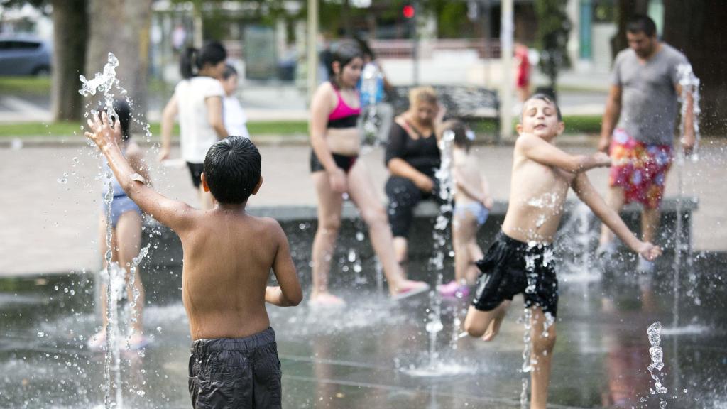 Unos niños refrescándose en una fuente en Salamanca durante una ola de calor