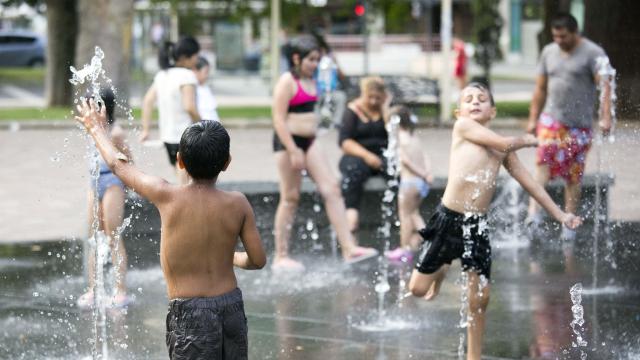 Unos niños refrescándose en una fuente en Salamanca durante una ola de calor
