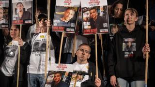 Los padres de los rehenes, en el escenario de la Plaza de los Rehenes, sostienen pancartas con los retratos de sus hijos, quienes aún se encuentran cautivos de Hamás.