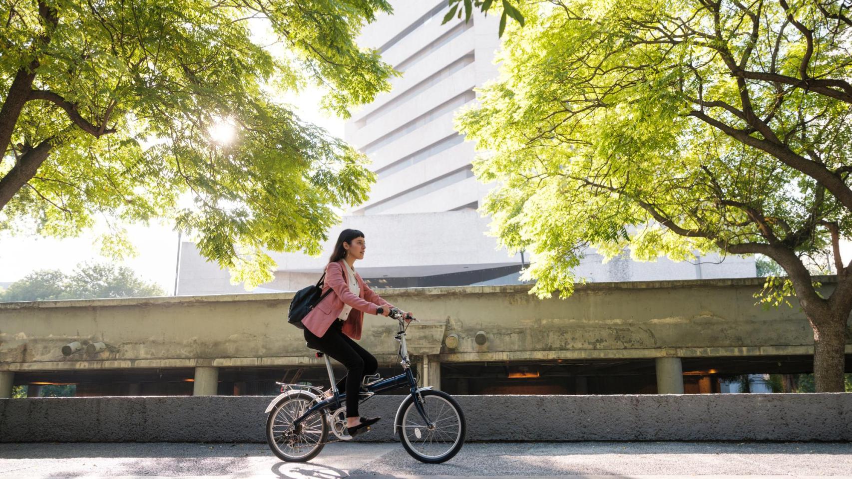 Una joven en bicicleta pasea por la ciudad.