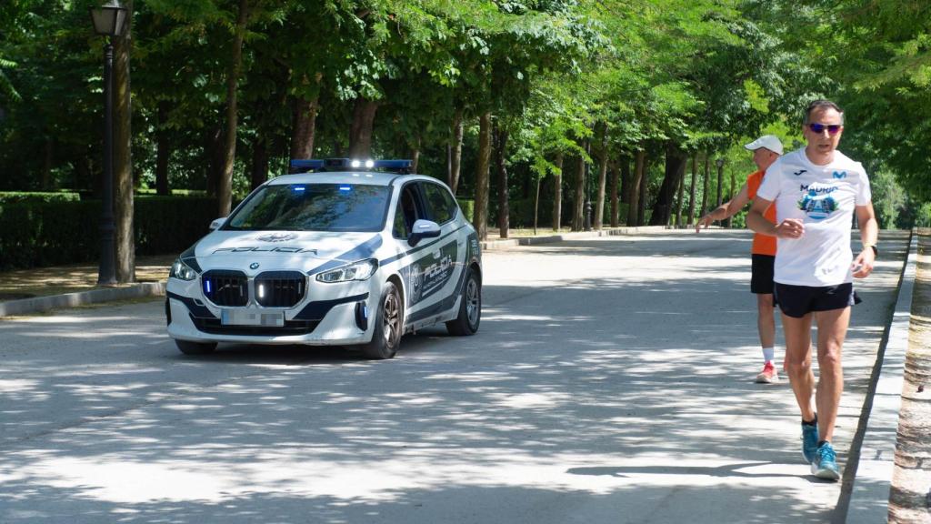Unos hombres corren por el Parque de El Retiro bajo el sol.