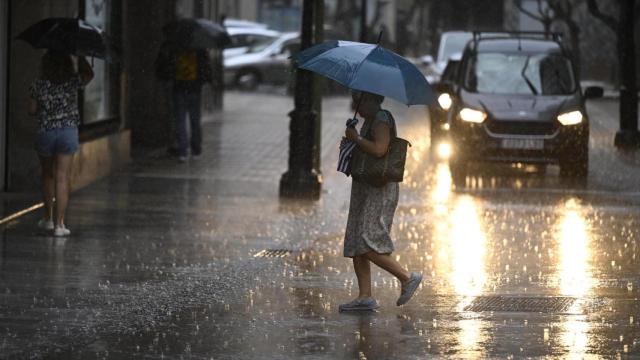 Una mujer protegiéndose de la lluvia en una imagen de archivo.