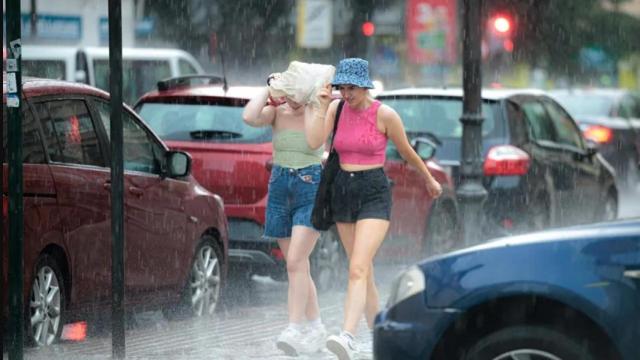 Dos personas caminan bajo la tormenta en Valencia.