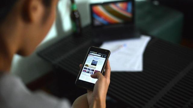 Una persona consultando su teléfono móvil en una imagen de archivo.