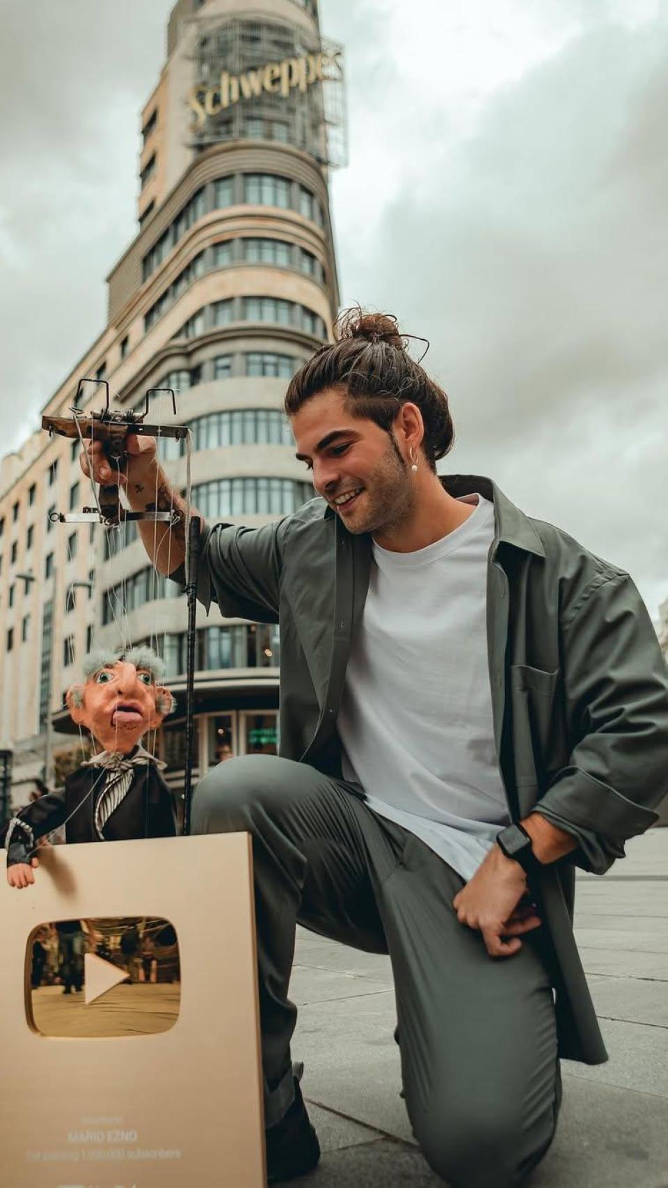 Mario Enzo junto a su marioneta Manolo y la placa de un millón suscriptores de su canal de YouTube.