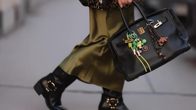 Imagen de 'street style' de una chica llevando un Birkin de Hermès customizado con 'charms'.