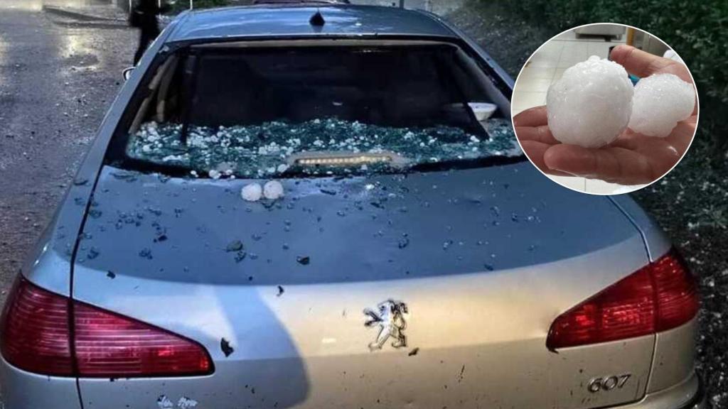 Uno de los coches destrozados y el granizo que ha caído