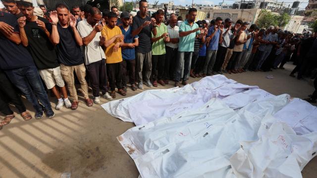 Decenas de personas cerca de los cuerpos de los palestinos que murieron en los ataques israelíes nocturnos, al sur de la Franja de Gaza.