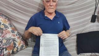 Domingo, en su casa de Torre Pacheco, mostrando la denuncia que ha presentado tras ser apaleado por un joven.