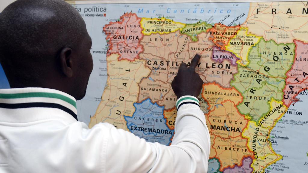 Un inmigrante señalando Castilla y León en un mapa