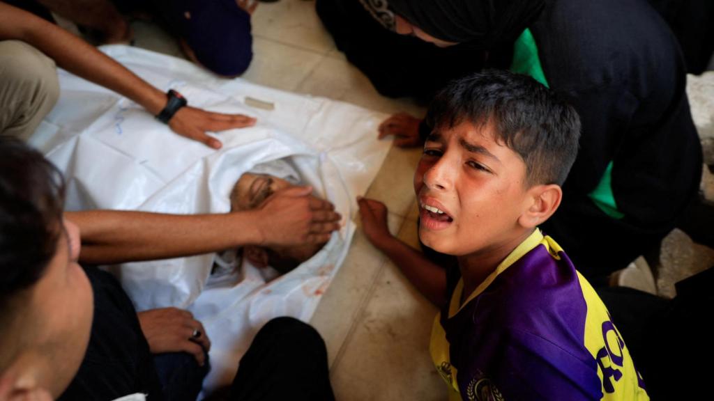 Un niño palestino llora junto al cuerpo de su padre, muerto por un ataque israelí.