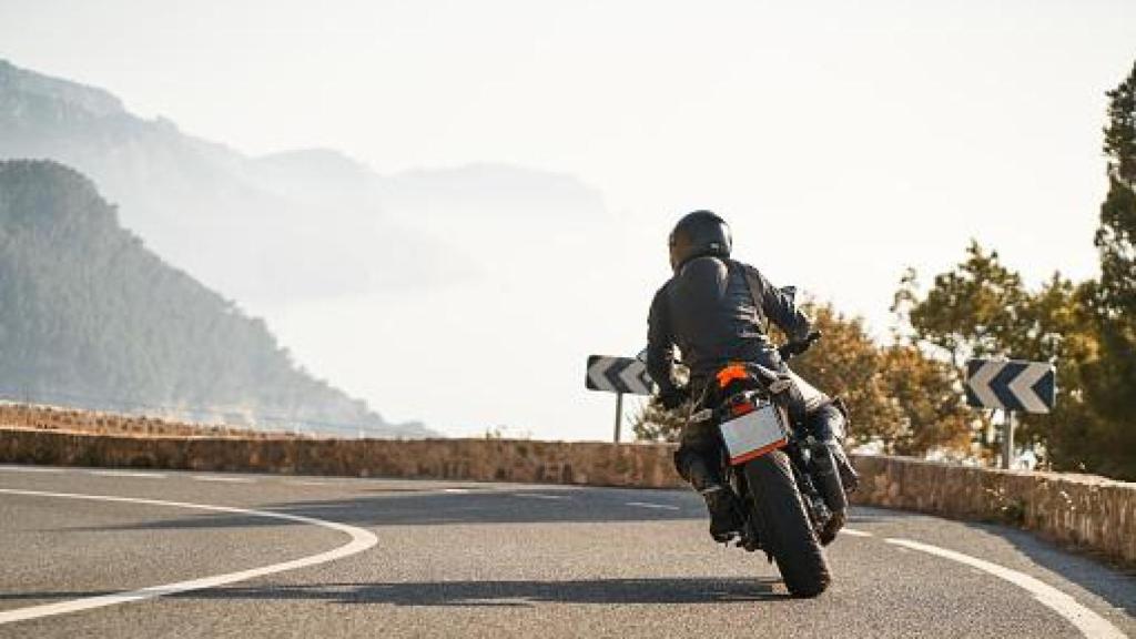 Imagen de un motorista en una curva de montaña.