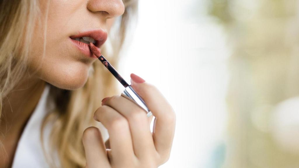 Mujer pintándose los labios.