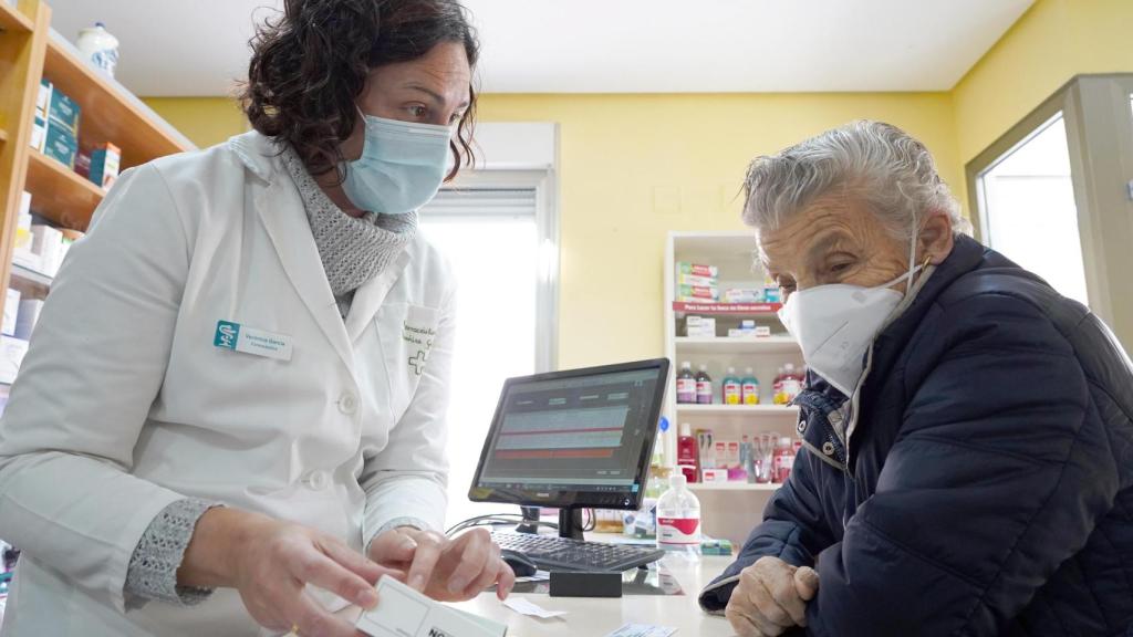 Verónica García, propietaria de la farmacia de la localidad vallisoletana de Geria, atiende a una vecina