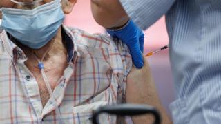 Un enfermero vacunando a un anciano en una residencia