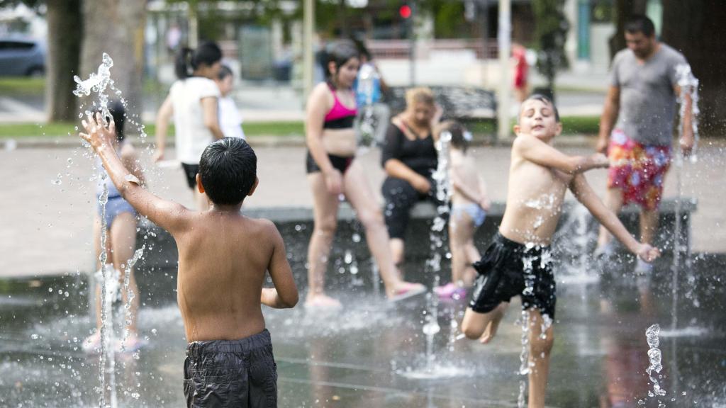 Un grupo de niños refrescándose en una fuente de Salamanca