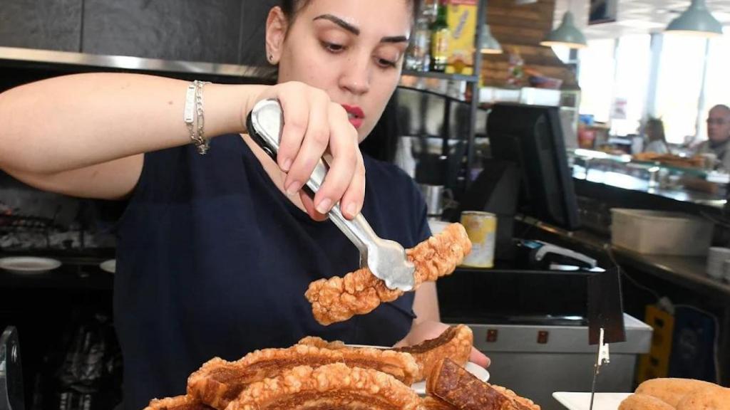 Una camarera sirviendo torreznos en el restaurante Área 280.